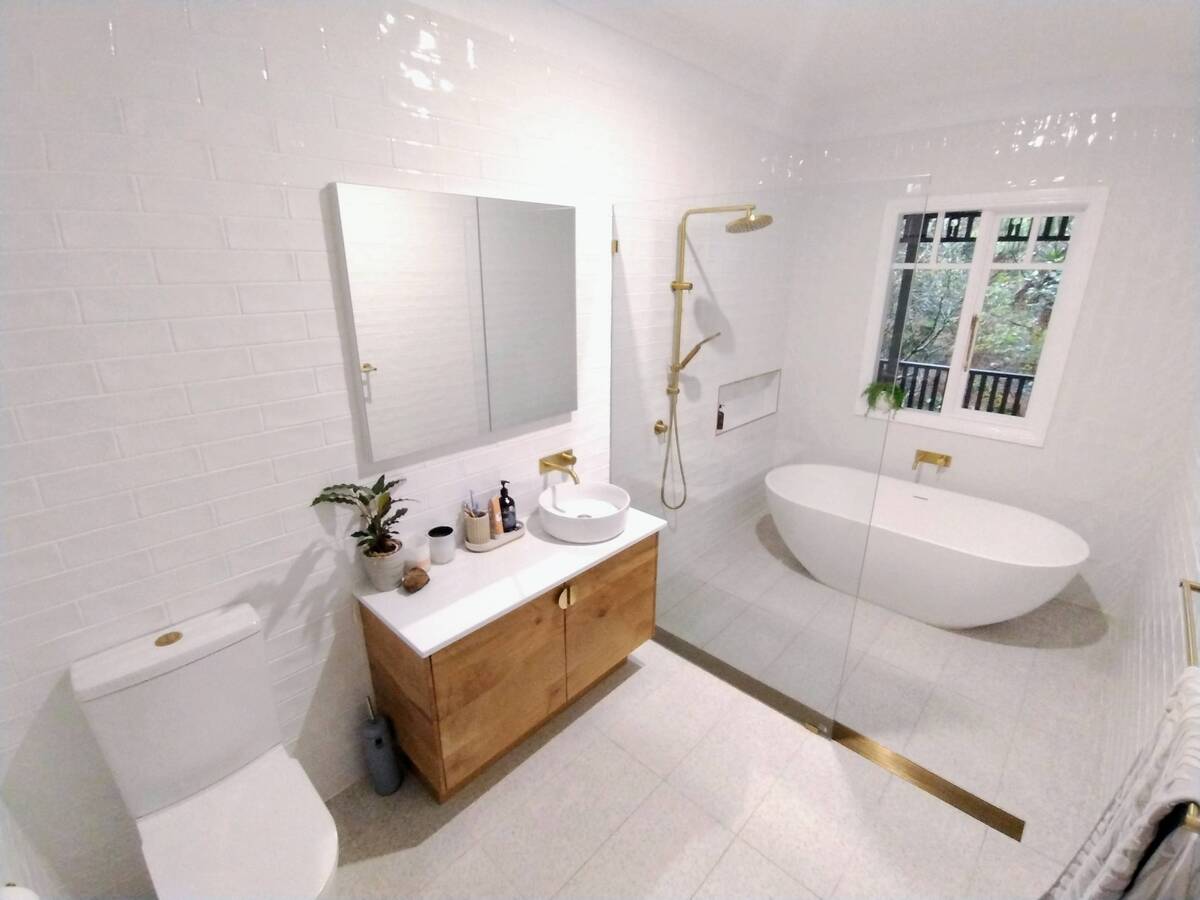 Contemporary bathroom with a freestanding bathtub, shower and wooden vanity.