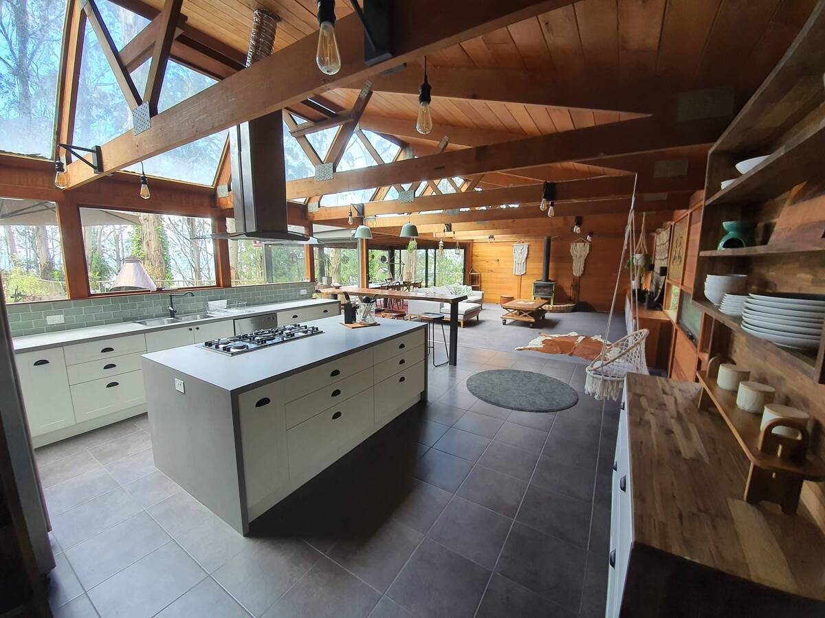 Contemporary kitchen with an open layout, wooden beams and a central island.